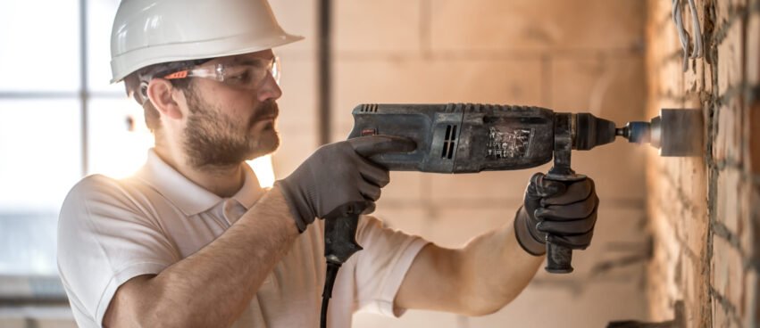 Handyman uses jackhammer, for installation, professional worker on the construction site. The concept of electrician and handyman. House and house reconstruction. SSUCv3H4sIAAAAAAAACpyRz27DIAzG75P2DhHnRgo0SdO9SrWDA06DSqECsmmq+u7jT5g474Z/tj/7M8/3t6YhMzjJyUfzjFGIpVKb8xa8NDrg7rBzi1qgrQkK6Y2VoGo4g+erhjsGqDelIn6lJHEe/ObQxWE74uDxGjQy/JPIG11y3JRESoaOkCLkUDG3zYkVlMX/1Zkfn8UNXFHzn7RwZcSiQshGLrmU3L492nttDTYhTeXqy3BQseBYKT2s5FJfqzbj13Tl0sbNpr2NKxBGz2V5oox5wKzilZcgi4Wv4FzoEIVXs3j4VnOvRmnjk4f9JESEz4ghPTLas+FEWT9M7Dx23V6QP3CVQSdtVIRCzG9S1O5l3ICw/sSGsR9bgWJpexxpO7F5agWlCwLtcBmmcPvXLwAAAP//AwDfznFoigIAAA==